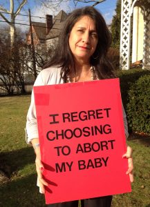 Georgette Forney holds the original "I Regret My Abortion" sign