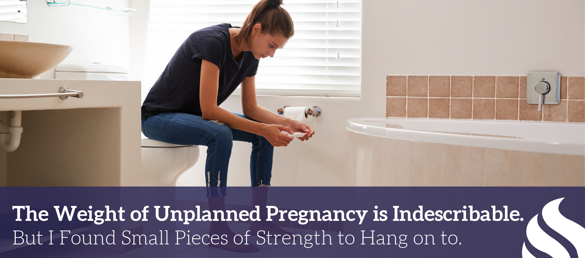 Woman sitting in bathroom looking at pregnancy test