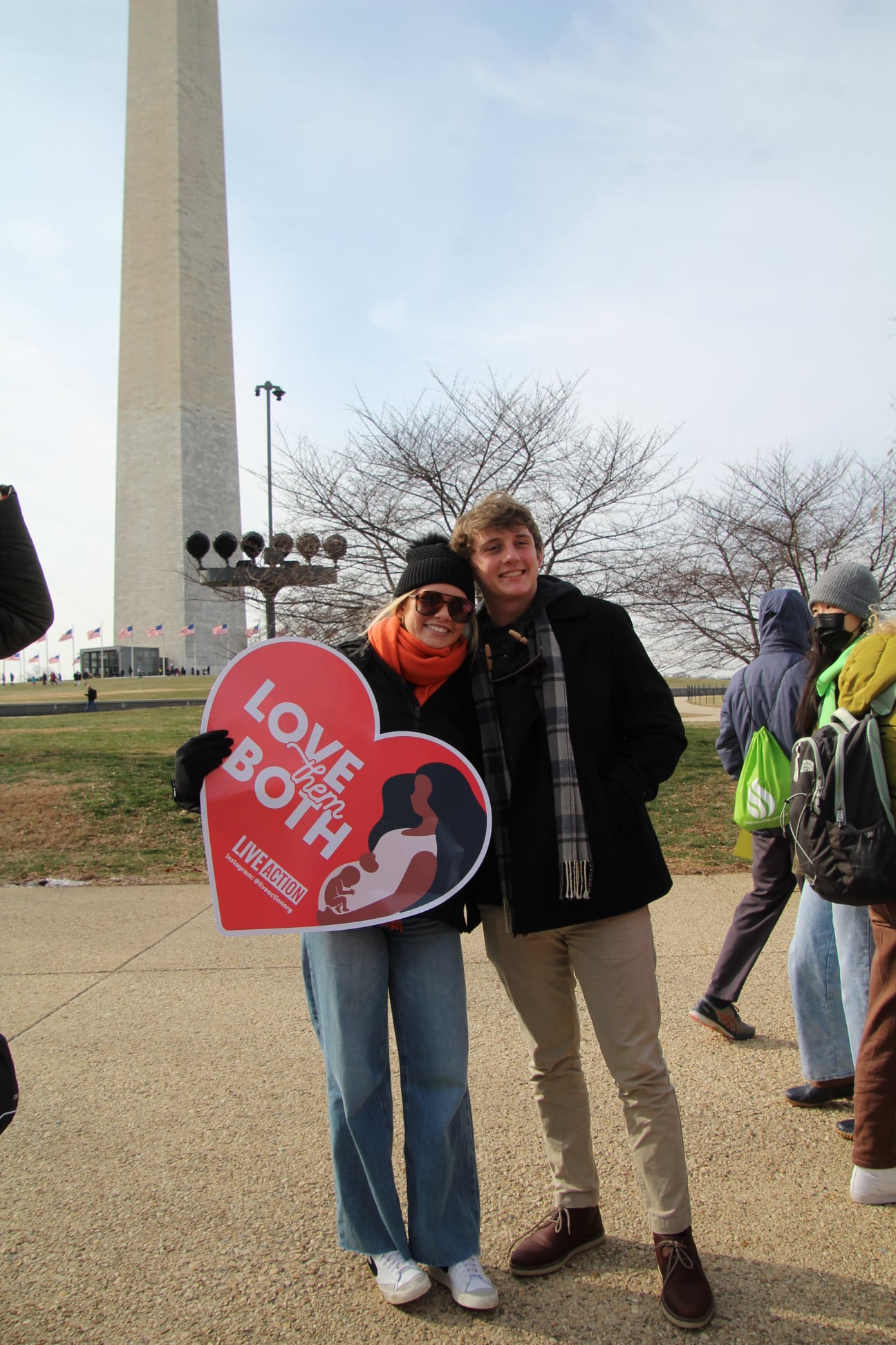 people at the march for life with a "love them both" sign.
