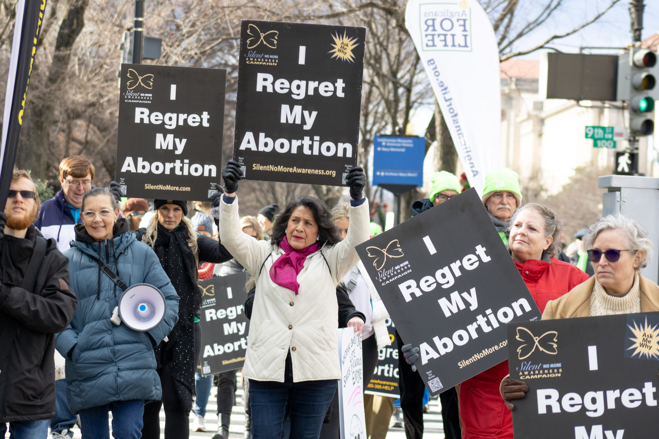 Woman holding "I regret my abortion" sign 