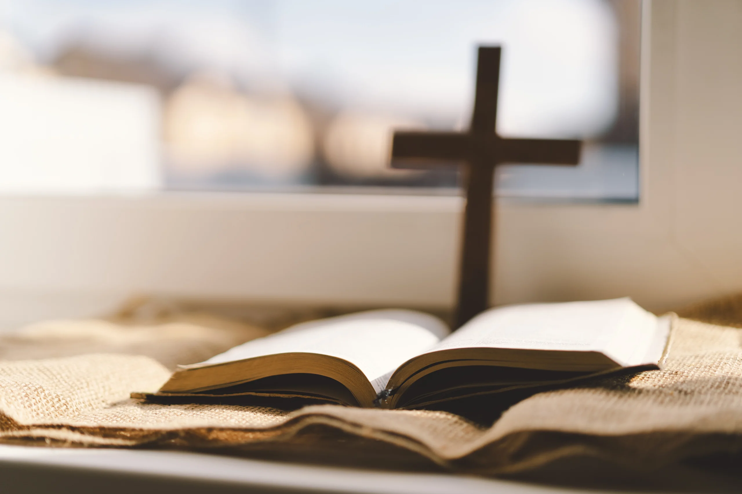 holy Bible with a cross on top of it